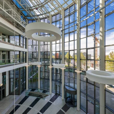 Die lichtdurchflutete Empfangshalle des Astropark-Bürogebäudes in Frankfurt mit raumhoher Glasfassade.
