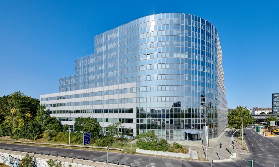Moderne Gesamtansicht eines Bürogebäudes mit Glasfassade in Berlin bei klarem Himmel.