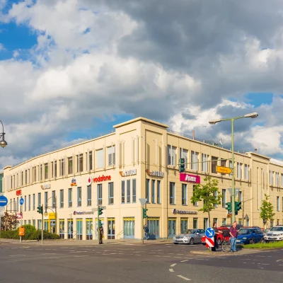 Außenansicht des Einkaufszentrums „Der Clou“ in Berlin mit Sicht auf verschiedene Einzelhändler.