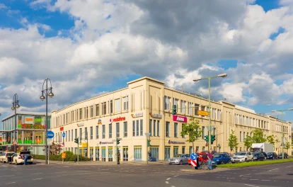 Außenansicht des Einkaufszentrums „Der Clou“ in Berlin mit Sicht auf verschiedene Einzelhändler.