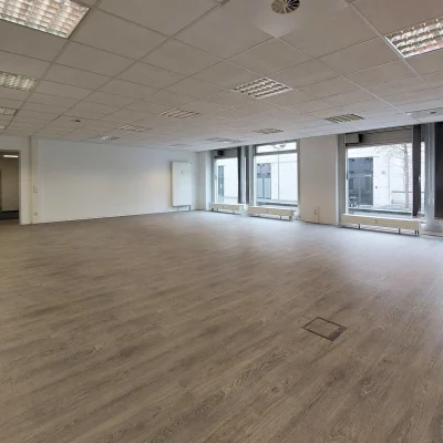 Das Bild zeigt eine leere Bürofläche im Trigon Office in Dresden mit großen Fenstern und hellem Bodenbelag.