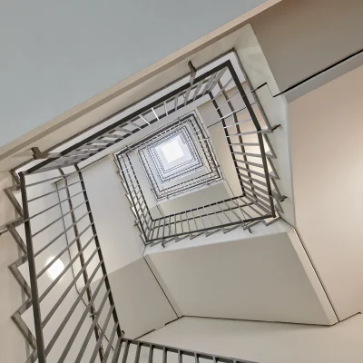 Das Bild zeigt das zentrale Treppenhaus im Trigon Office Dresden mit geometrischer Perspektive und Tageslichteinfall von oben.