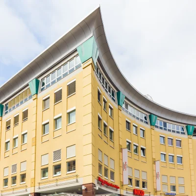 Abgebildet ist die Ecke des Einkaufszentrums Marktplatz Center Berlin mit mehreren Geschäften und Restaurants.