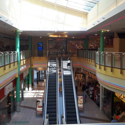 Das Bild zeigt die Ladenpassage mit Rolltreppe und Glasdach im Inneren des Marktplatz Centers.