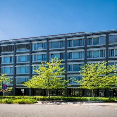Ein moderner Bürokomplex in Eschborn mit klarer Straßenansicht und begrüntem Umfeld.