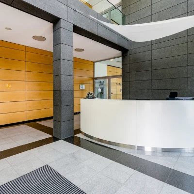 Der Empfangsbereich eines Bürogebäudes mit modernem Design und geschwungener Theke.
