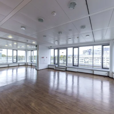 Ein leeres Büro in Eschborn mit großzügiger Fensterfront und viel Tageslicht.