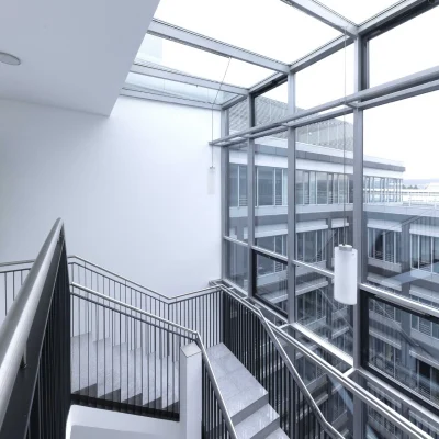 Blick auf ein Treppenhaus mit großer Glasfassade und moderner Gestaltung.