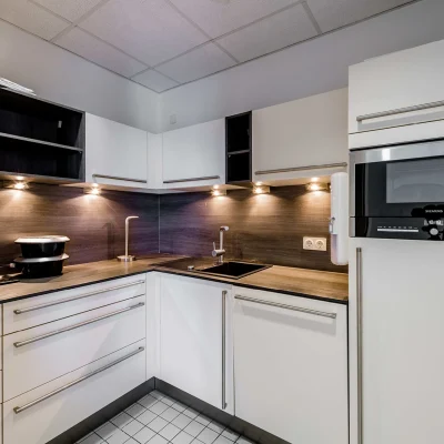 Das Bild zeigt eine moderne Einbauküche in einer Büroeinheit des HAT64 Frankfurt mit Kaffeemaschine und Stauraum.
