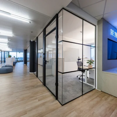 Das Bild zeigt eine Büroetage im SIGMA Frankfurt mit großzügigem Flurbereich, Loungeelementen und Glasbürowänden.