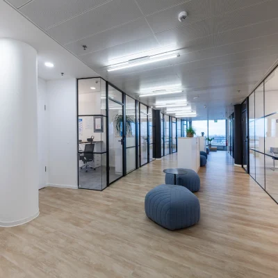 Das Bild zeigt eine moderne Büroetage im SIGMA-Gebäude Frankfurt mit Glaswänden, Lounge-Sitzgelegenheiten und hellem Holzfußboden.