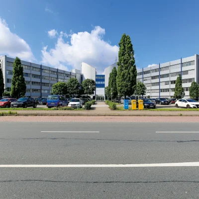 Das Bürogebäude Brandboxx in Hannover ist frontal mit großem Parkplatz und markantem Eingangsbereich zu sehen.