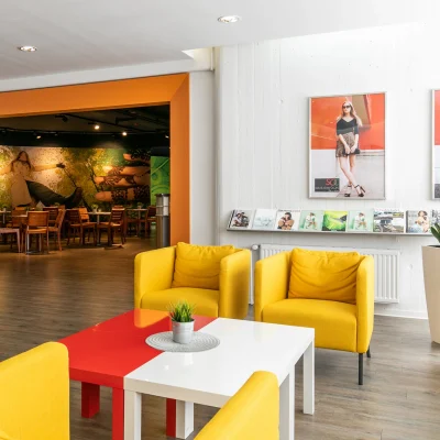 Freundlich gestalteter Lounge- und Wartebereich mit gelben Sesseln und moderner Einrichtung in Hannover.