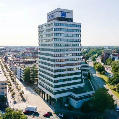 Blick von oben auf einen modernen Büroturm in Hannover, der sich markant ins Stadtbild einfügt.