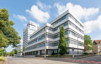 Das Bild zeigt die moderne Außenansicht eines Bürogebäudes in Hannover mit klarer Architektur und großen Fensterflächen.