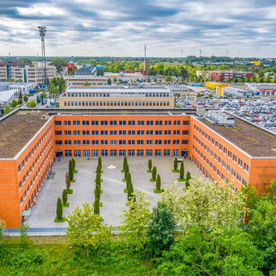Das Bild zeigt den Innenhof des Bürokomplexes Kontorhof Teltow in Berlin aus der Vogelperspektive mit symmetrisch bepflanztem Platz.