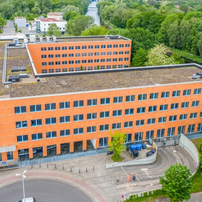 Das Bild zeigt den Haupteingang des Kontorhofs Teltow in Berlin mit umliegendem Grünbereich aus der Vogelperspektive.