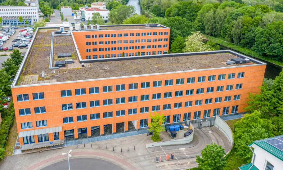 Das Bild zeigt den Haupteingang des Kontorhofs Teltow in Berlin mit umliegendem Grünbereich aus der Vogelperspektive.