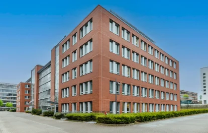 Außenansicht eines modernen Bürogebäudes mit Backsteinfassade und großen Fensterflächen in Eschborn.