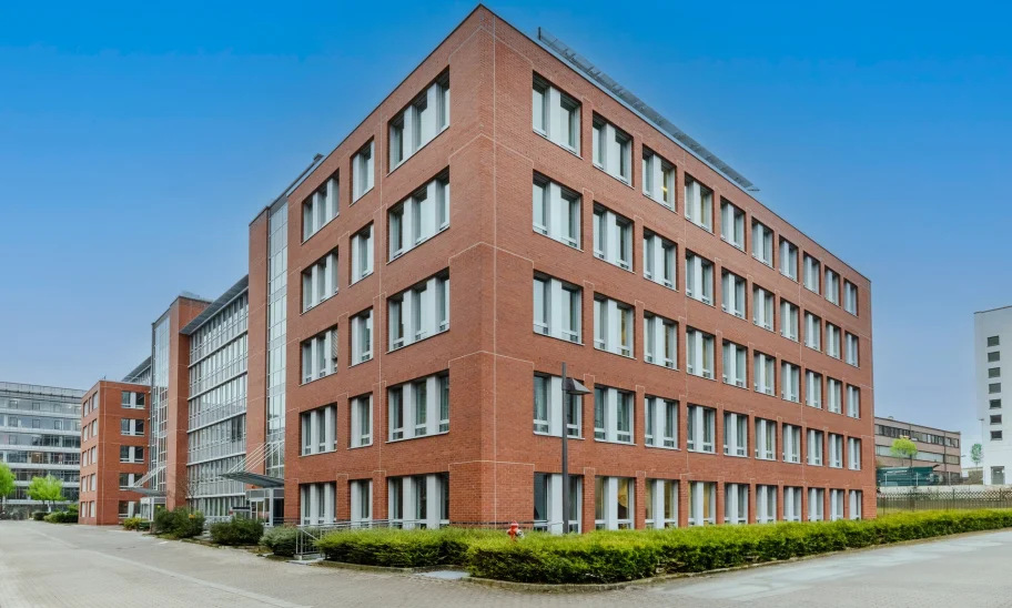 Außenansicht eines modernen Bürogebäudes mit Backsteinfassade und großen Fensterflächen in Eschborn.