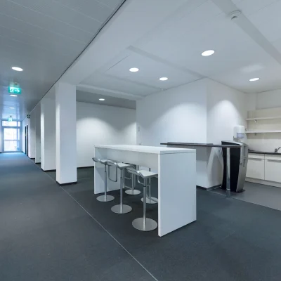 Aufenthaltsbereich mit Teeküche und Sitzmöglichkeiten in einem modernen Bürogebäude in Eschborn.