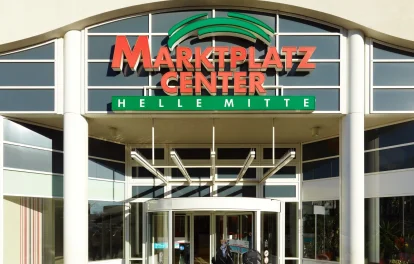 Abgebildet ist der Haupteingang des Marktplatz Centers Berlin-Hellersdorf mit Glasfassade und großem Logo.