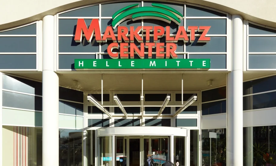 Abgebildet ist der Haupteingang des Marktplatz Centers Berlin-Hellersdorf mit Glasfassade und großem Logo.
