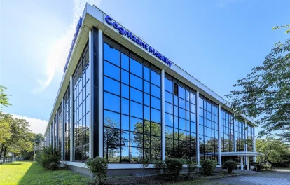 Moderne Außenansicht eines Bürohauses mit großer Glasfassade und Eck-Eingang im Pegasus Business Center in München.