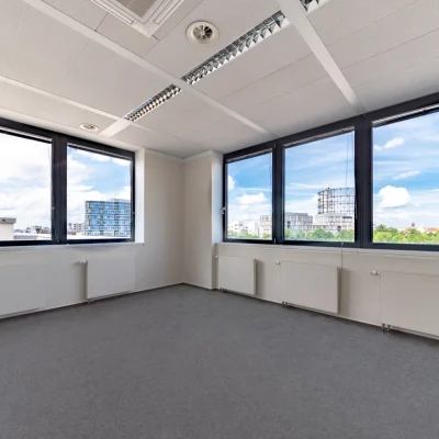 Leeres, lichtdurchflutetes Büro in Berlin mit großen Fenstern und weitem Ausblick.