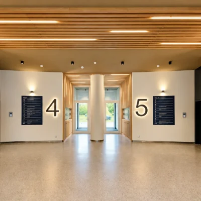 Lobby des Platinum Office am Sachsendamm in Berlin mit Holzlamellen, Aufzügen und beleuchteten Hausnummern 4 und 5