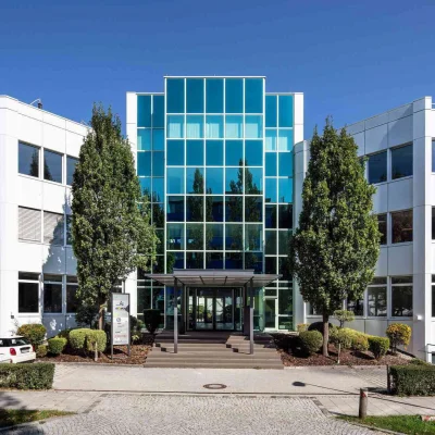 Die moderne Büroimmobilie in Dornach bei München zeigt einen symmetrischen Innenhof mit markantem Glasdach und klarer Architektur.