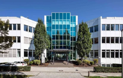 Die moderne Büroimmobilie in Dornach bei München zeigt einen symmetrischen Innenhof mit markantem Glasdach und klarer Architektur.