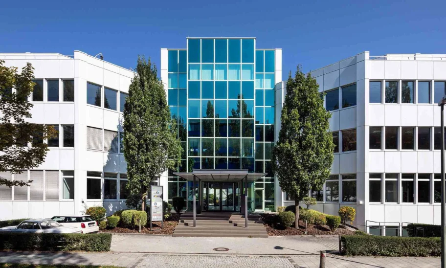 Die moderne Büroimmobilie in Dornach bei München zeigt einen symmetrischen Innenhof mit markantem Glasdach und klarer Architektur.