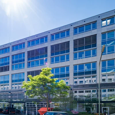 Die Aufnahme zeigt die Fassade eines sechsstöckigen Bürogebäudes in Frankfurt bei Tageslicht.