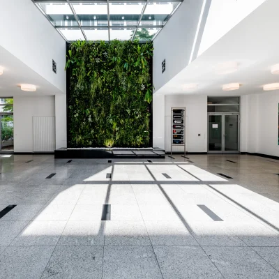 Der Empfangsbereich eines Bürogebäudes in Frankfurt ist mit einer begrünten Wand und modernem Design ausgestattet.
