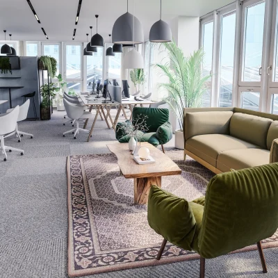 Zu sehen ist ein heller, moderner Büroraum mit Arbeitsplätzen, gemütlichen Sitzmöbeln und vielen Pflanzen in einem Open-Space-Layout.