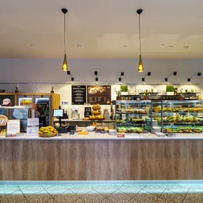 Thekenbereich eines modernen Cafés im Gewerbepark mit Snacks, Backwaren und Kaffeeangebot.
