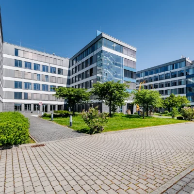 Das Bild zeigt einen modernen Konferenzraum mit Glaswänden und Blick auf das Außengelände des Trevista-Areals in Eschborn.