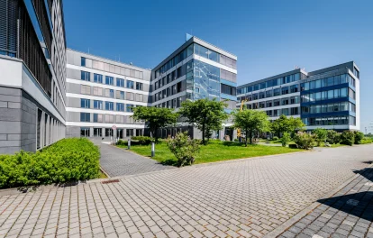 Das Bild zeigt einen modernen Konferenzraum mit Glaswänden und Blick auf das Außengelände des Trevista-Areals in Eschborn.