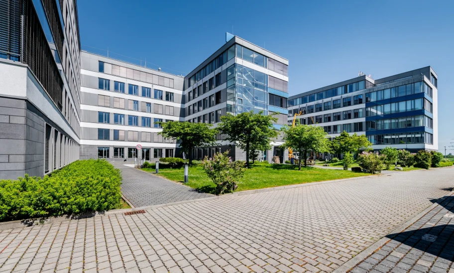 Das Bild zeigt einen modernen Konferenzraum mit Glaswänden und Blick auf das Außengelände des Trevista-Areals in Eschborn.