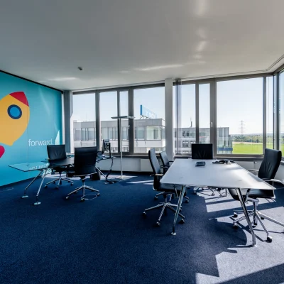 Das Bild zeigt ein modernes Bürogebäude des Trevista-Areals in Eschborn mit großflächiger Glasfassade und gepflegter Außenanlage.