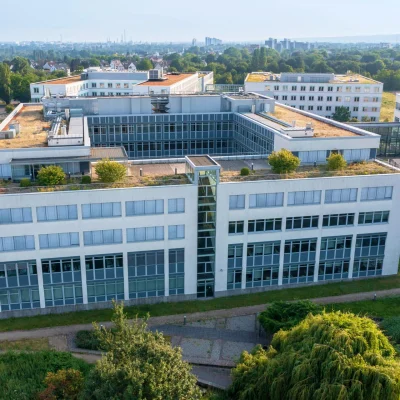 Luftaufnahme des modernen Bürogebäudes Tricubes in Frankfurt mit Dachgarten und Blick über die Stadt.