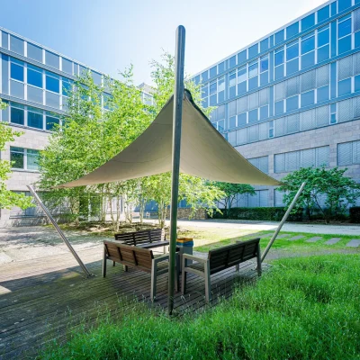 Büro-Innenhof mit Sitzmöbeln und Sonnensegeln als Aufenthaltsbereich.