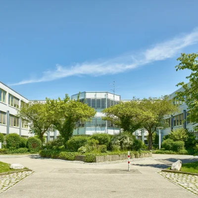 Aussenansicht des Type1 Office Bürogebäudes mit Bäumen und Pflanzen im Vordergrund.