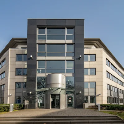 Das Bild zeigt die zentrale Frontansicht eines Bürogebäudes mit Eingangsbereich und Glasfassade in Bonn.