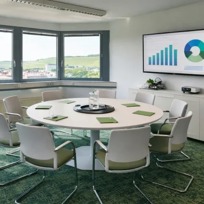 Besprechungsraum mit rundem Konferenztisch und Panoramablick über Weinberge und Altstadt