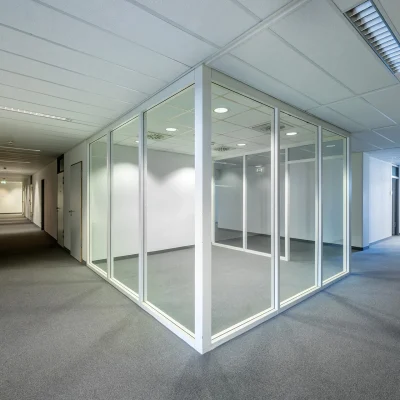 Lichtdurchflutete Büroeinheit mit Glas-Trennwänden und angrenzendem Flur in einem modernen Bürokomplex.