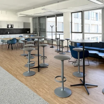 Der Pausenraum in einem Frankfurter Büro ist mit einer Teeküche, Stehtischen, Sitzgelegenheiten und großen Fenstern ausgestattet.