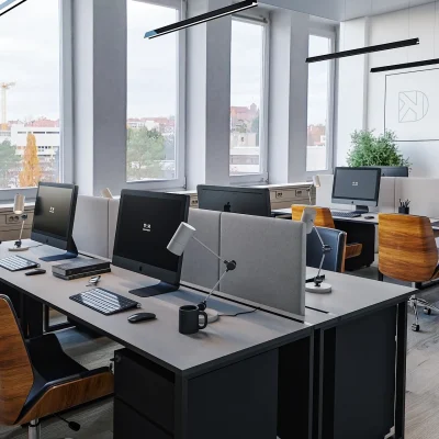 Das Bild zeigt ein modernes Open-Space-Büro im Deutschherrnkarree mit mehreren Arbeitsplätzen, Monitoren und Design-Bürostühlen.