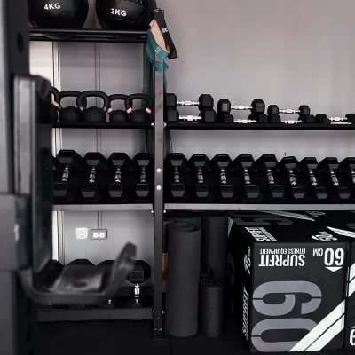 Auf dem Bild sind Hanteln und Gewichtsscheiben in einem Fitnessstudio-Bereich eines modernen Bürogebäudes zu sehen.